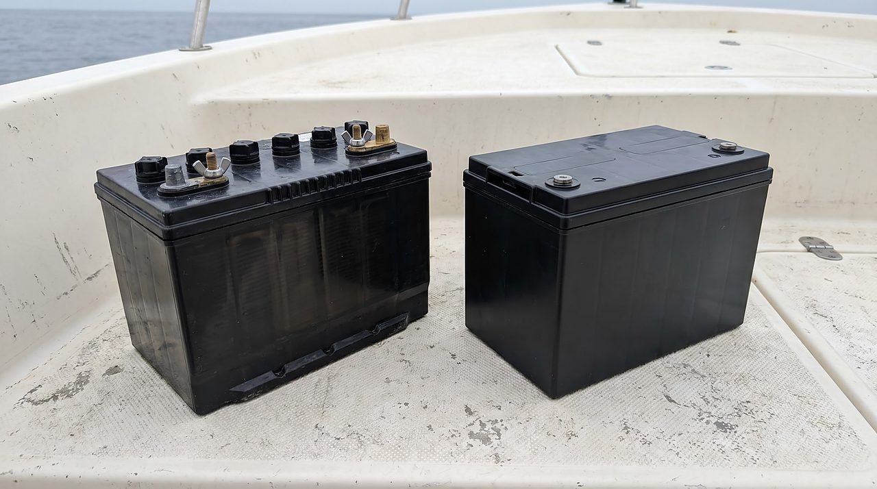 two generic marine batteries side by side on a boat deck, flooded and AGM types