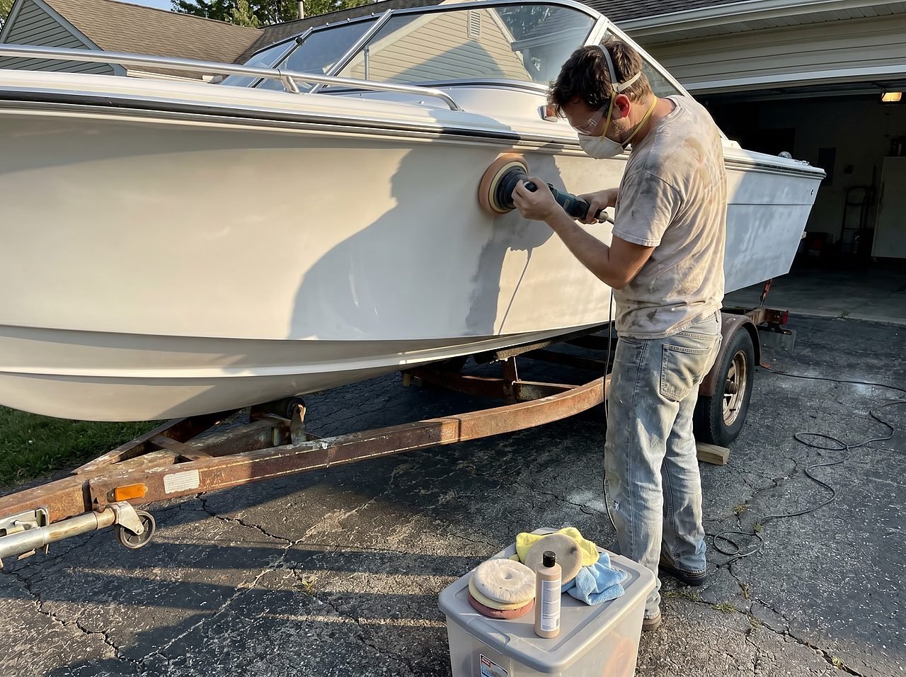 DIY boat restoration in progress showing contrast between buffed and oxidized hull sections