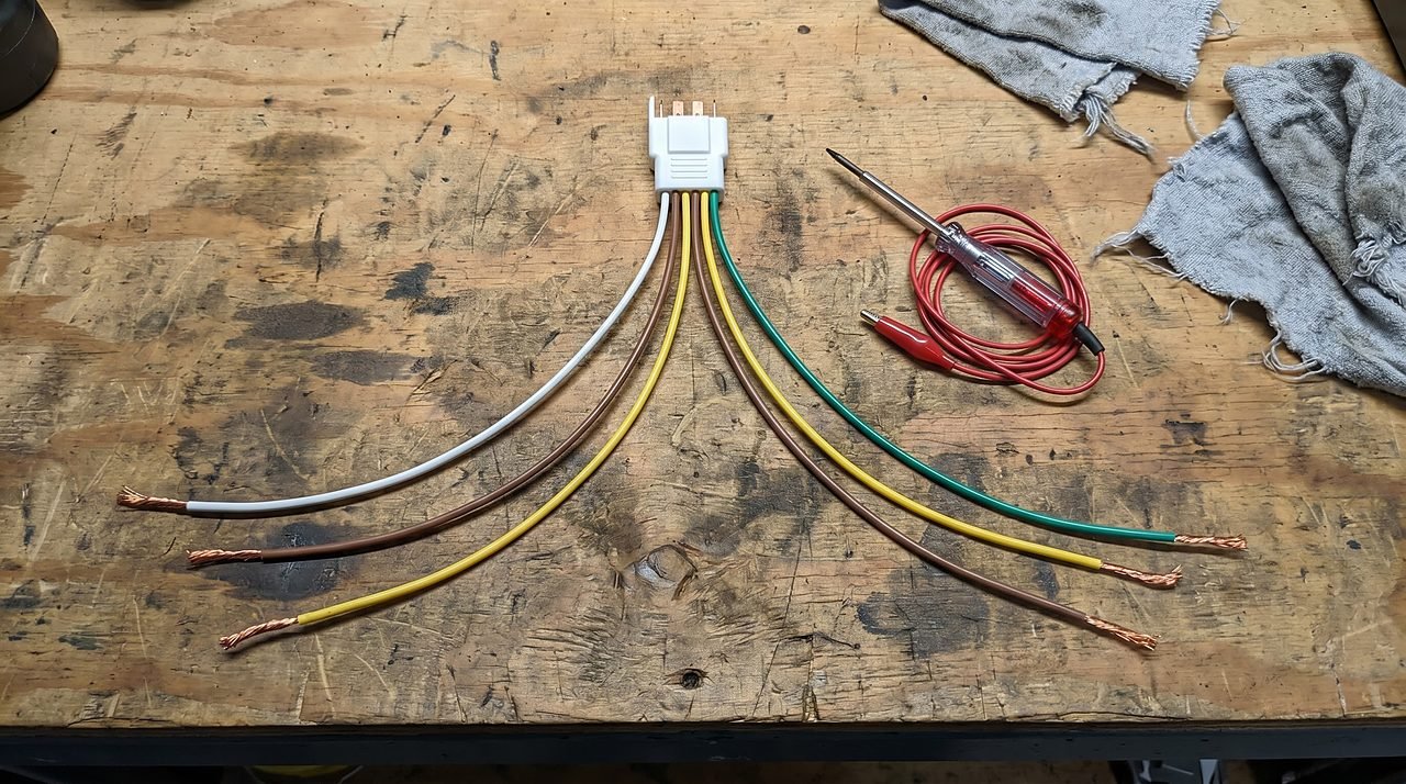 four color-coded wires of a 4-pin boat trailer harness spread on a workbench