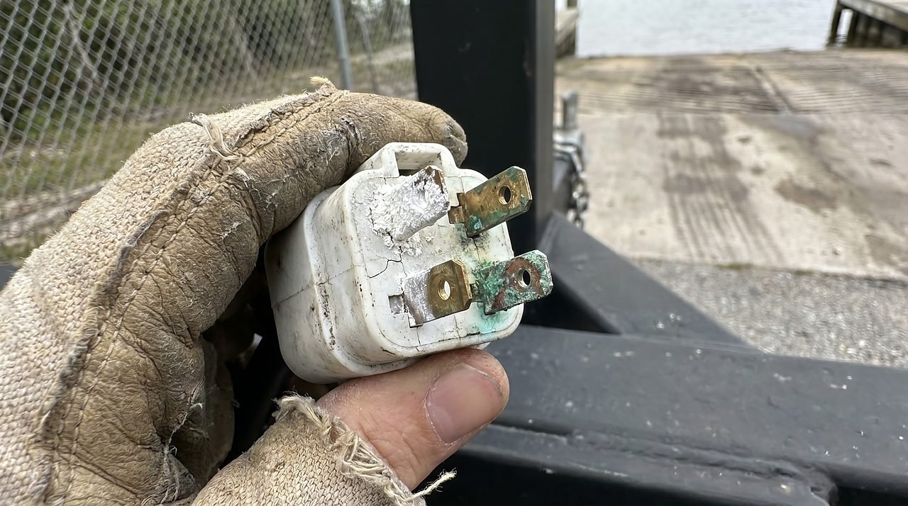 corroded 4-pin trailer connector showing green and white oxidation on boat trailer