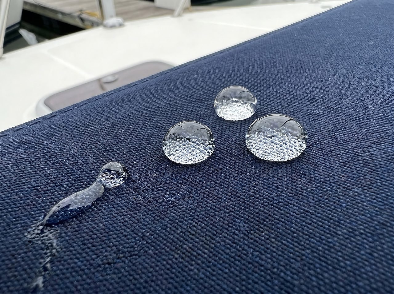 water droplets beading on treated marine canvas demonstrating intact DWR waterproofing