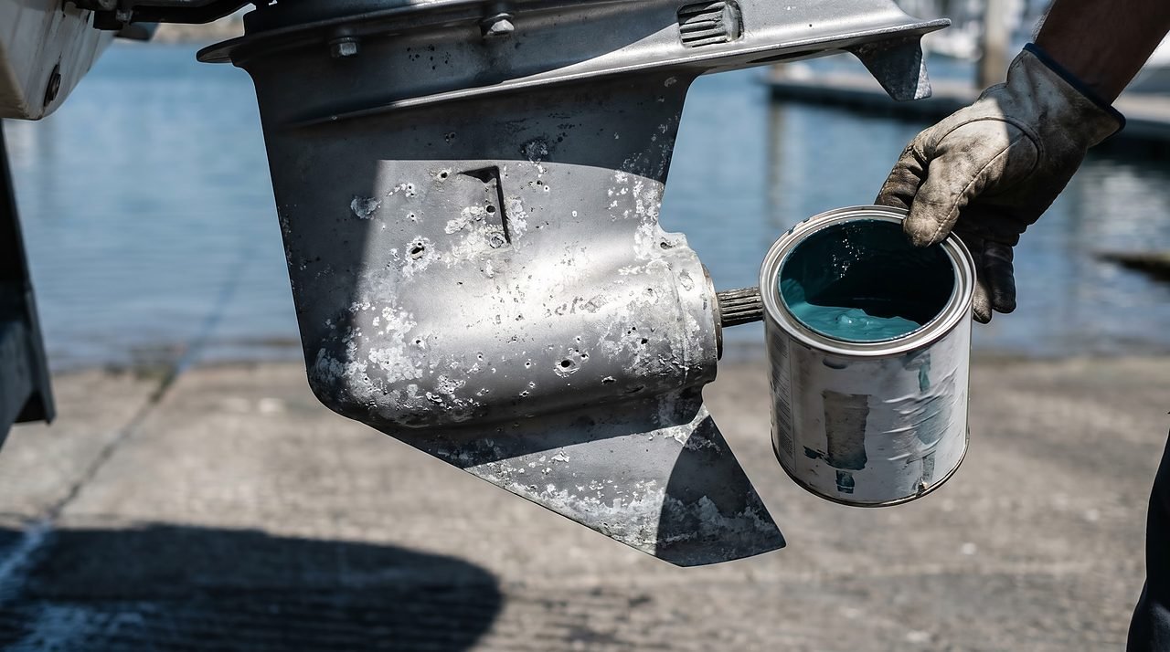 corroded aluminum outdrive gearcase showing galvanic pitting damage next to copper-free antifouling paint