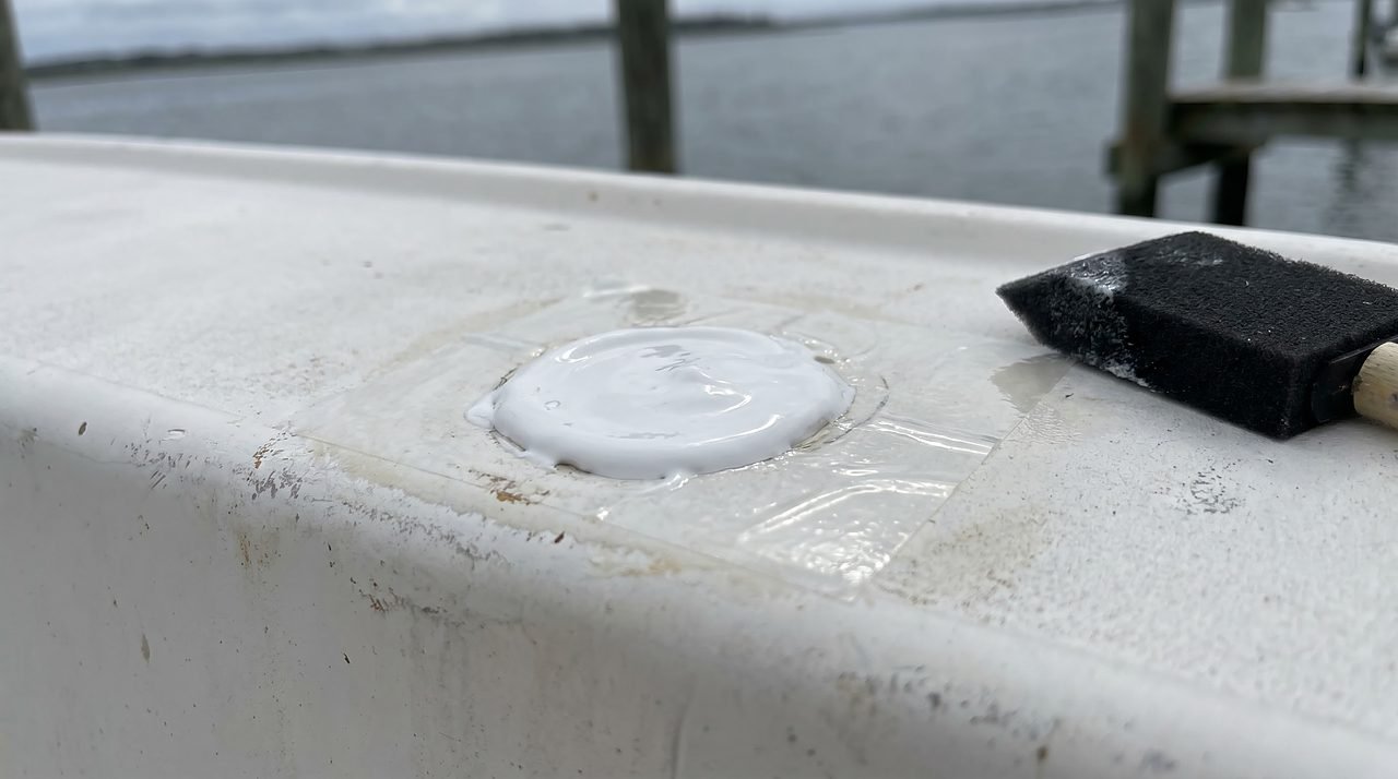 PVA film applied over fresh gelcoat repair on a weathered white fiberglass hull